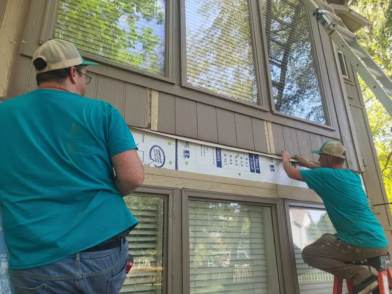 Crew installing siding and trim