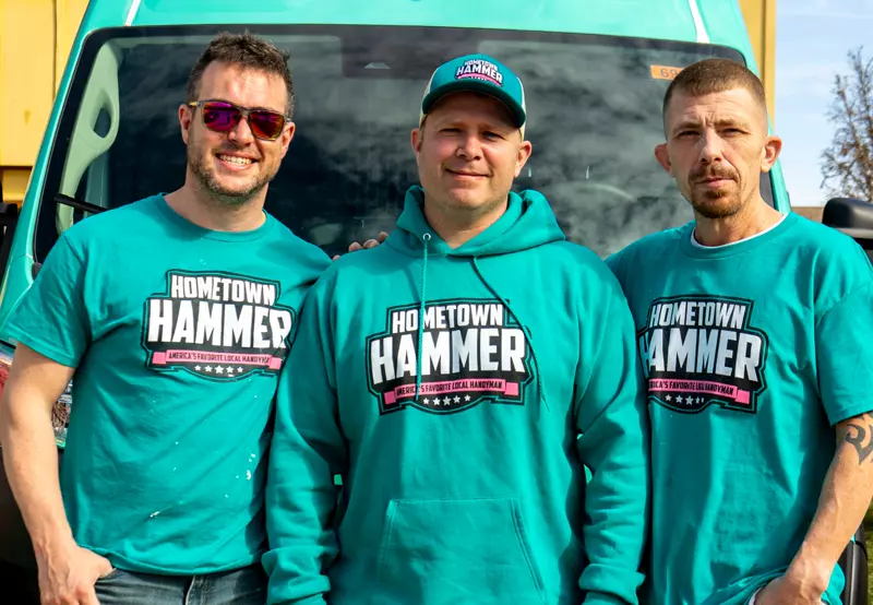 Three Hometown Hammer team members in front of a work van